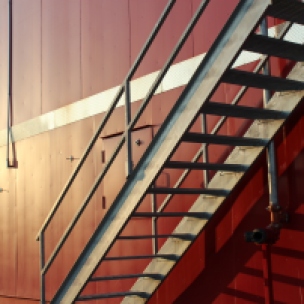 a shot of a staircase on the side of a beautifully colored fire house.